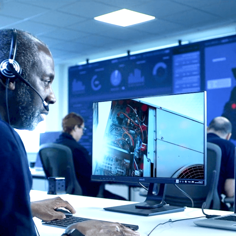米蒂技术澳博官方网站运营中心的远程维修人员. Wearing a headset and looking at a monitor, seeing what an engineer is seeing on site